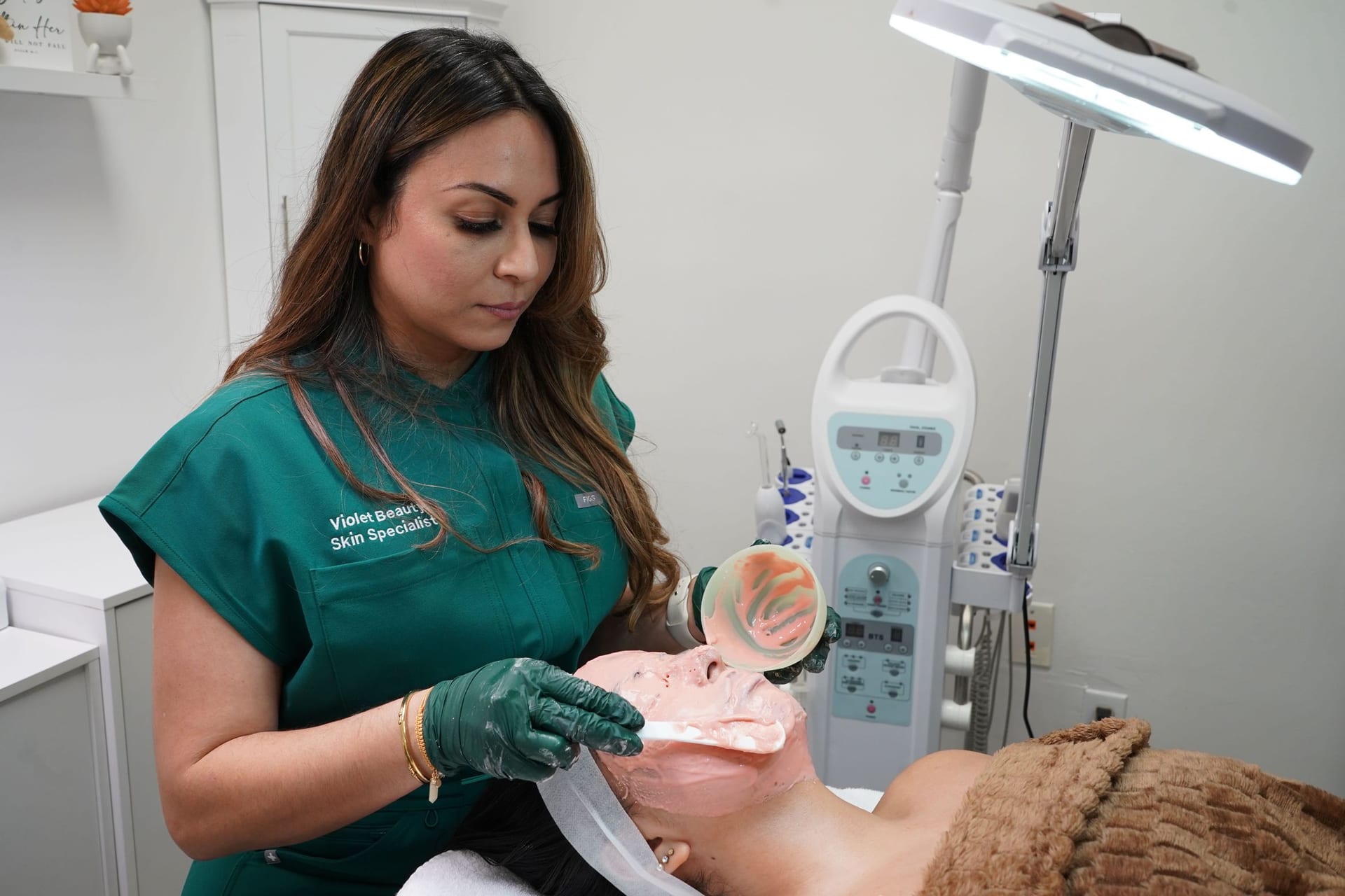 Violeta applying a mask during a facial